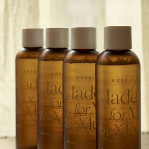 Selenaire AXIS-Y Biome Comforting Infused Toner in a clear bottle with a white cap, showing the product label and liquid inside.